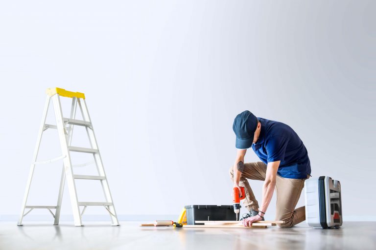 Handyman assembling white flat-pack bookshelf in Birmingham home